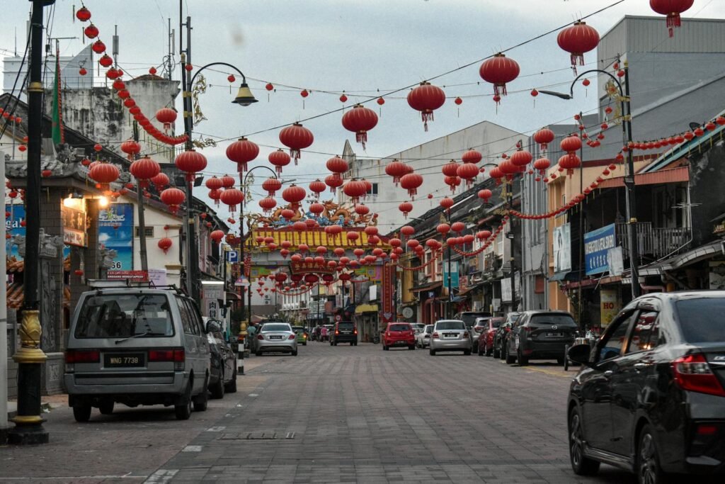 A vibrant street in Chinatown decorated with traditional red lanterns during daytime.